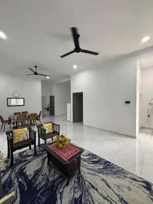 a living room with chairs and a ceiling fan at D'Laman Homestay in Slim River