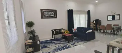 a living room with a blue couch and a table at D'Laman Homestay in Slim River