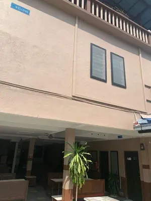 a building with chairs and a plant in front of it at Nipah Bay Villa in Pangkor