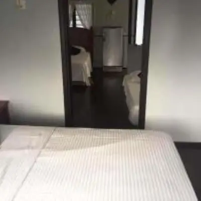 a bedroom with a white bed and a mirror at Nipah Bay Villa in Pangkor