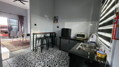 a kitchen with a sink and a counter with a table at Yash Cottage Taiping Homestay in Taiping