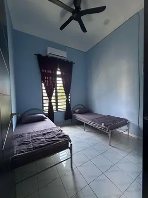 a bedroom with two beds and a ceiling fan at Yash Cottage Taiping Homestay in Taiping