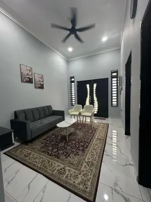 a living room with a couch and a ceiling fan at Yash Cottage Taiping Homestay in Taiping