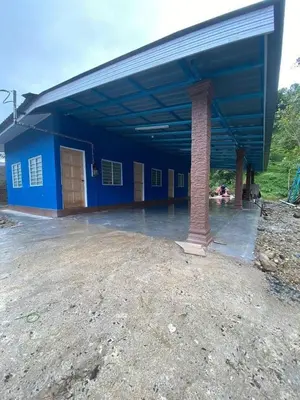 a blue building with a pole in front of it at Mikhail Roomstay in Dabung