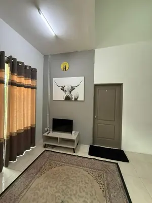 a living room with a picture of a cow on the wall at Botani Lodge in Ipoh