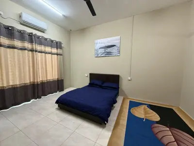 a bedroom with a bed with a blue comforter at Botani Lodge in Ipoh