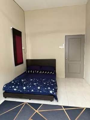 a bedroom with a bed with a blue blanket at Botani Lodge in Ipoh