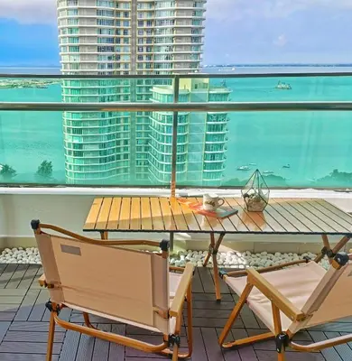 a table and chairs on a balcony with a view of the ocean at Gurney Drive Mansion One by RL SUITE in George Town