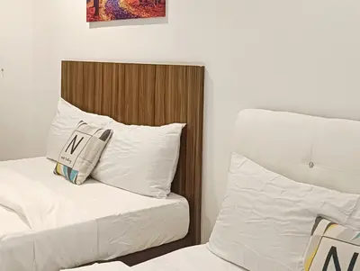 two beds with white sheets and pillows in a room at Gurney Drive Mansion One by RL SUITE in George Town