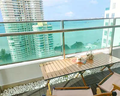 a balcony with a table and chairs and a view of the ocean at Gurney Drive Mansion One by RL SUITE in George Town