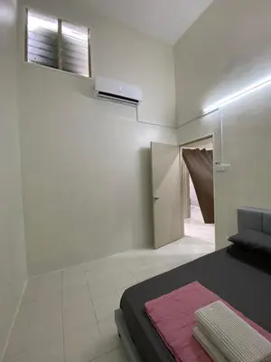 a white room with a bed with a pink blanket at Sofea Homestay Tasek Gelugor in Kampong Kubang Menderong