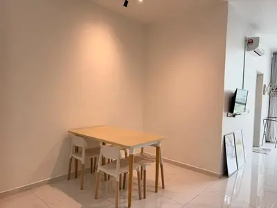 a table and chairs in a room with a wall at Perffect JB view Paradigm UTM in Gua Sai