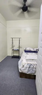 a room with two beds and a ceiling fan at Ummi Studio Homestay in Bayan Lepas
