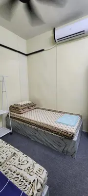 a room with two beds in a room at Ummi Studio Homestay in Bayan Lepas