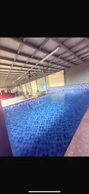 a large swimming pool with blue tiles on the floor at Ummi Studio Homestay in Bayan Lepas