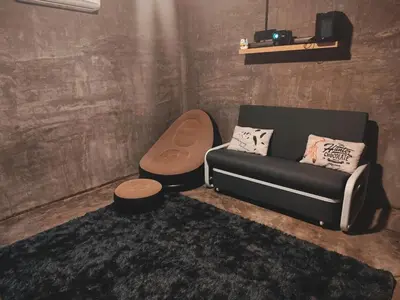a living room with a couch and a stool at Afqa Nest Industrial Charm in Gua Sai