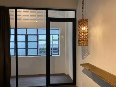 a room with a glass door and a window at Chowrasta Suites by Aayu George Town Penang in George Town