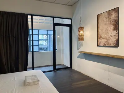 a room with a bed and a large window at Chowrasta Suites by Aayu George Town Penang in George Town