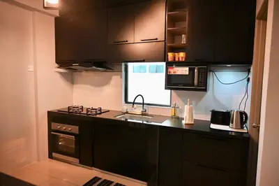 a kitchen with black cabinets and a black counter top at CK Home in Ipoh