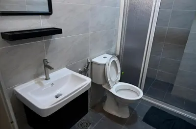 a bathroom with a white toilet and a sink at CK Home in Ipoh