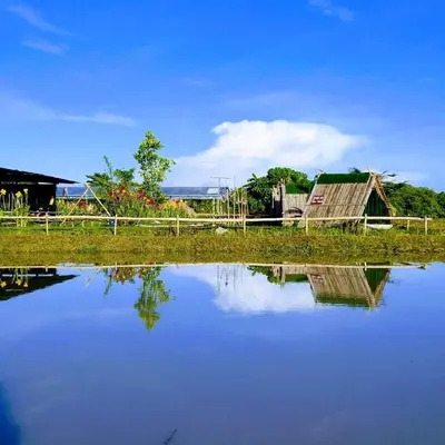 a body of water with a barn and a house at Tatami Room Malay Wooden Stay in Balik Pulau