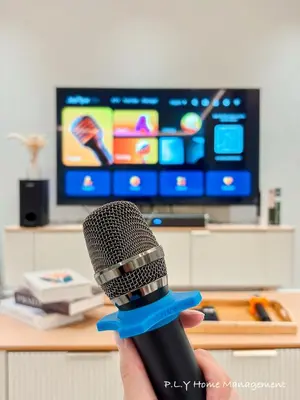 a person holding a microphone in front of a television at HH Villa Private Pool Bercham Ipoh in Ipoh