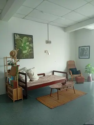a bedroom with a bed and a coffee table at Bajet Homestay - Teratak Singgah in Seri Iskandar