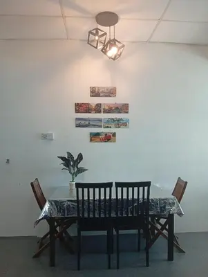 a dining room table with two chairs and a lamp at Bajet Homestay - Teratak Singgah in Seri Iskandar