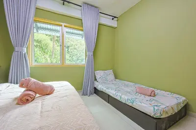 a bedroom with two beds and a window at Modern Family Suite in Tanah Rata Cameron Highlands Clover Home K2 in Cameron Highlands