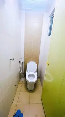 a bathroom with a toilet and a green door at APPARTMENT Samudera Manjung Point in Seri Manjung