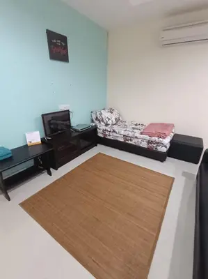 a room with a bed and a table and a rug at Marina Island Lumut in Lumut