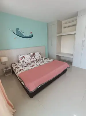 a bedroom with a bed with a pink comforter at Marina Island Lumut in Lumut