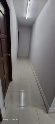an empty hallway with a door and a tile floor at Zahaar KN Inn in Batu Ferringhi