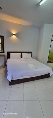 a bedroom with a large white bed in a room at Zahaar KN Inn in Batu Ferringhi