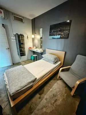 a bedroom with a large bed and a chair at HuttonSTAY at Georgetown in George Town