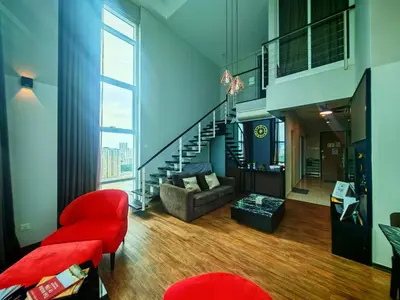 a living room with a staircase and a red chair at Maritime Suite by Ocean Luxe 2BR Seaview Dryer Water Dispenser in George Town