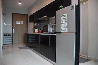 a kitchen with black cabinets and a refrigerator at Maritime Suite by Ocean Luxe 2BR Seaview Dryer Water Dispenser in George Town