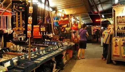 a group of people standing in a market selling items at Homestay Batu Ferringhi in Gua Sai