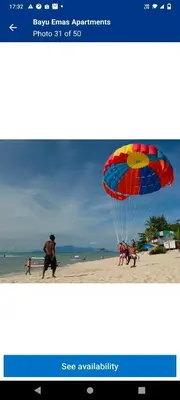 a picture of a person on a beach with a parachute at Homestay Batu Ferringhi in Gua Sai