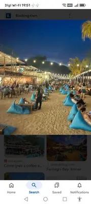 a group of people sitting on blue lounge chairs on the beach at Homestay Batu Ferringhi in Gua Sai