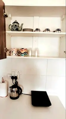 a kitchen counter with a tea kettle and dishes on shelves at #MyUrbanGetaway at CameronFair, Cameron Highlands in Tanah Rata