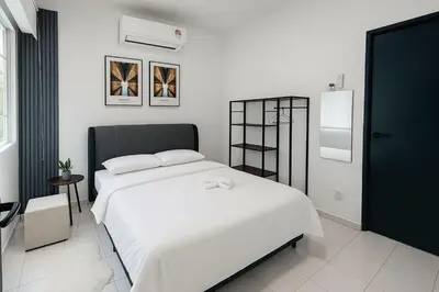 a bedroom with a large white bed in a room at 4BR Near SPICE Arena Free Parking in Bayan Lepas