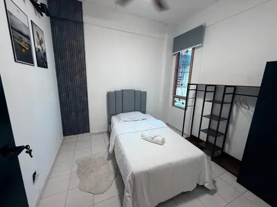 a bedroom with a bed with two white towels on it at 4BR Near SPICE Arena Free Parking in Bayan Lepas