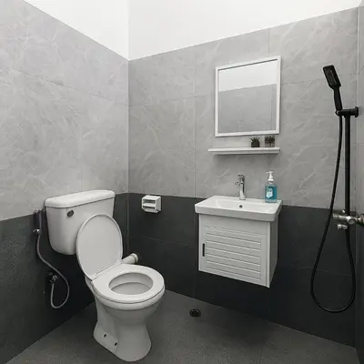 a bathroom with a toilet and a sink and a mirror at 4BR Near SPICE Arena Free Parking in Bayan Lepas