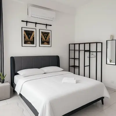 a white bedroom with a large bed with white sheets at 4BR Near SPICE Arena Free Parking in Bayan Lepas