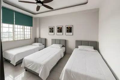 a bedroom with two beds and a ceiling fan at 4BR Near SPICE Arena Free Parking in Bayan Lepas