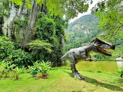 a statue of a dinosaur standing in the grass at The Haven Lakeside Residences, Lake View Suite IPOH in Gua Sai