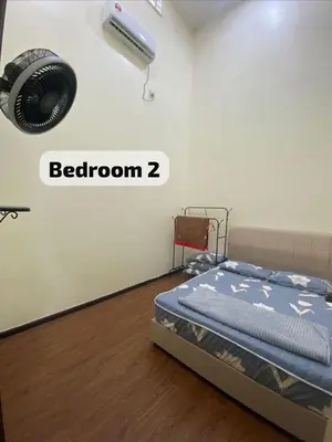 a bedroom with a bed and a fan on the wall at Mslim only Homestay Aleena Gua Musang in Gua Musang