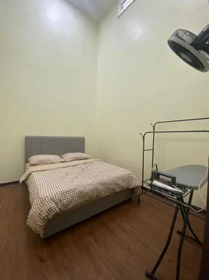 a bedroom with a bed and a mirror and a chair at Mslim only Homestay Aleena Gua Musang in Gua Musang