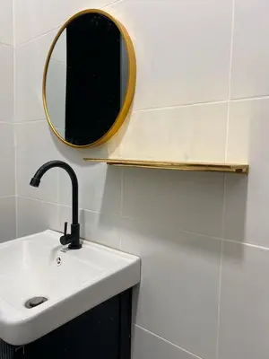 a bathroom with a sink and a mirror on the wall at Mslim only Homestay Aleena Gua Musang in Gua Musang